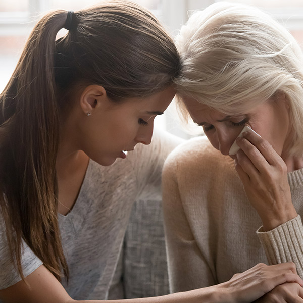 daughter and mother crying for the loss of a loved one