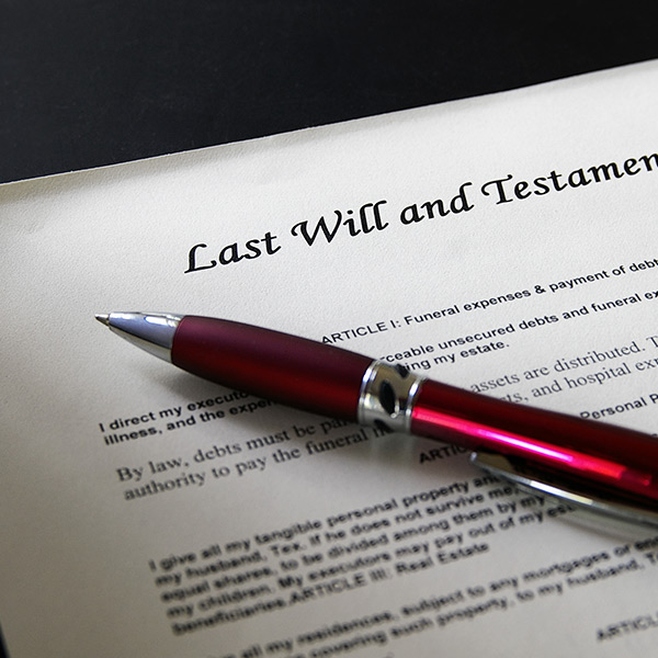 Red pen lying atop a last will and testament